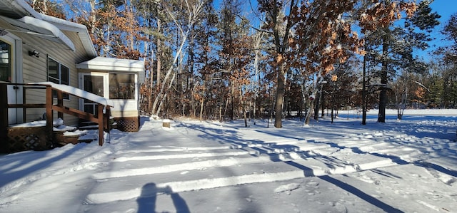 snowy yard with a sunroom