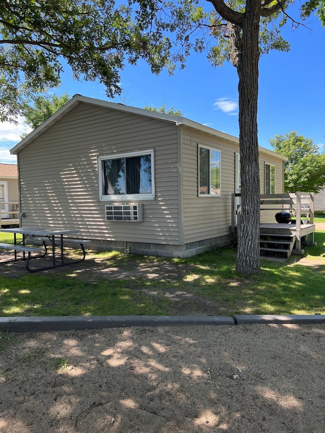 view of side of property with a wooden deck and a yard