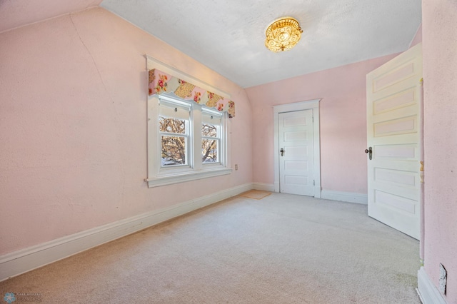 empty room featuring light carpet and lofted ceiling