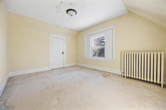 bonus room featuring lofted ceiling, carpet floors, radiator heating unit, and baseboards