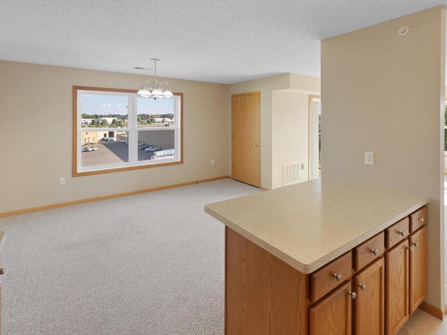 kitchen featuring decorative light fixtures, a textured ceiling, light carpet, and an inviting chandelier