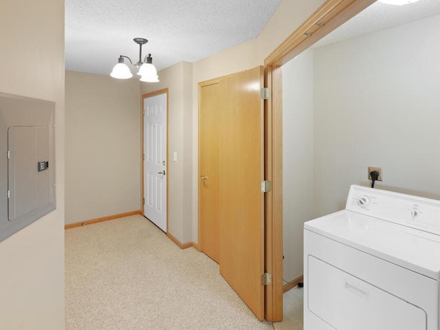 laundry area featuring a notable chandelier, washer / clothes dryer, a textured ceiling, light colored carpet, and electric panel