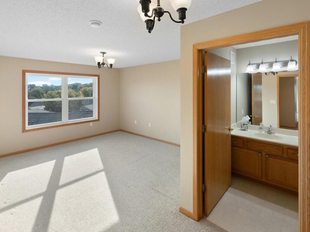 interior space featuring sink, a textured ceiling, light carpet, and a chandelier