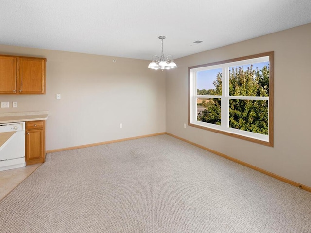 interior space featuring decorative light fixtures, a chandelier, light carpet, and white dishwasher