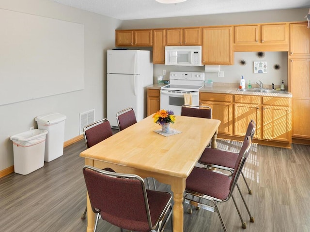 kitchen featuring sink, white appliances, and light wood-type flooring