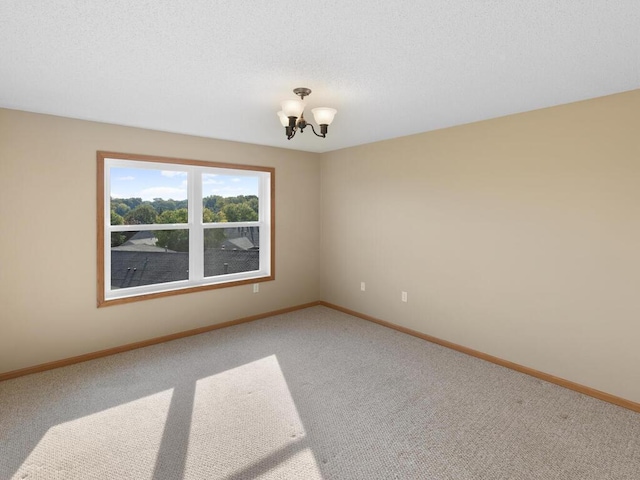 carpeted empty room with a notable chandelier