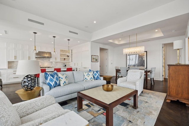 living room featuring dark wood-type flooring and a raised ceiling