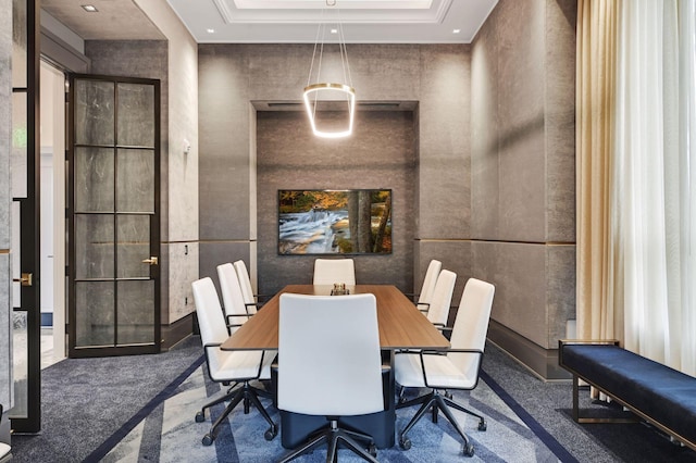 carpeted dining space with a raised ceiling and a towering ceiling