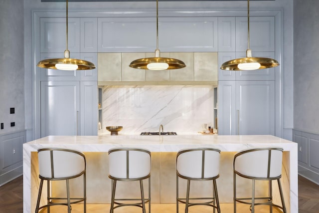 kitchen with parquet flooring, decorative light fixtures, and light stone countertops