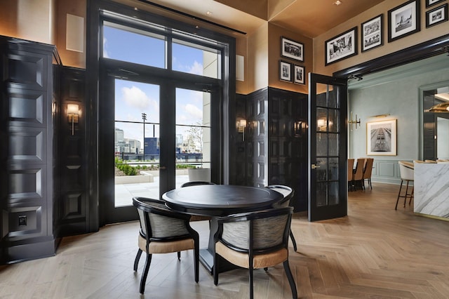 dining room with a high ceiling, parquet flooring, and french doors