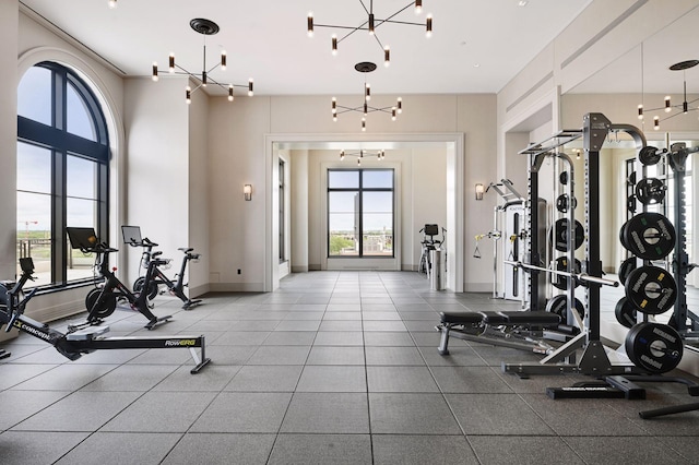 workout area with an inviting chandelier and a wealth of natural light