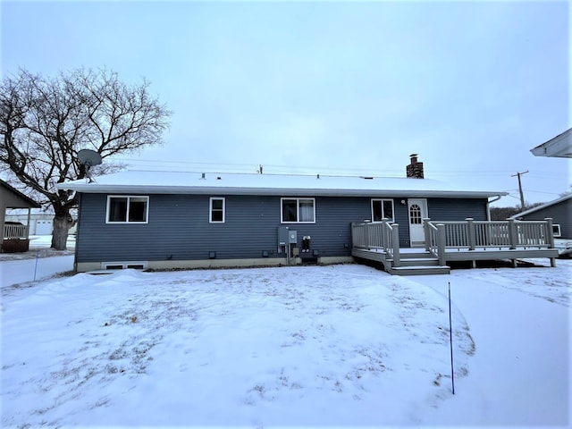 snow covered rear of property featuring a deck