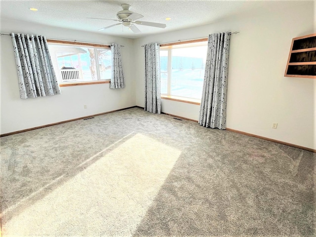 unfurnished room featuring carpet, ceiling fan, and plenty of natural light