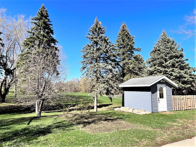 view of yard with a storage unit, an outdoor structure, and fence