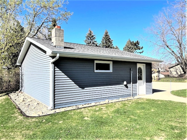 exterior space featuring a lawn, a chimney, and a shingled roof