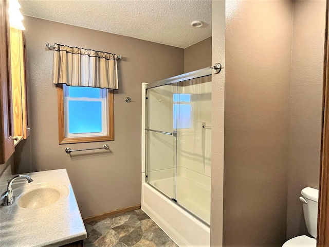 full bathroom with vanity, toilet, baseboards, bath / shower combo with glass door, and a textured ceiling