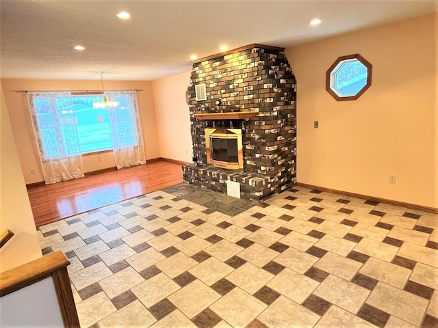 unfurnished living room with recessed lighting, a brick fireplace, a notable chandelier, and a wealth of natural light
