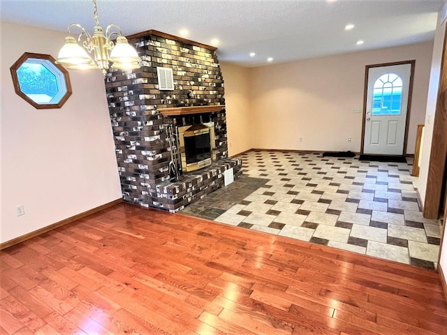 unfurnished living room featuring a brick fireplace, recessed lighting, baseboards, and hardwood / wood-style floors