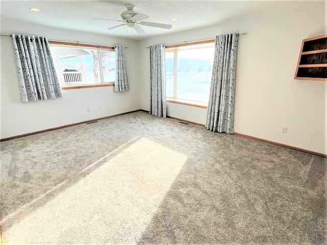 empty room featuring carpet floors, ceiling fan, and baseboards