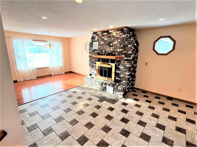 unfurnished living room featuring an inviting chandelier, a fireplace, baseboards, recessed lighting, and a textured ceiling