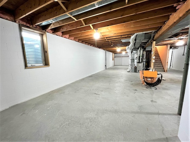 below grade area featuring heating unit and stairway