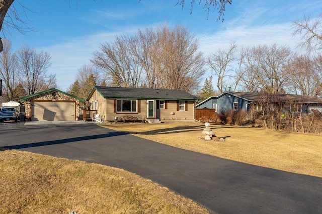 single story home with an outbuilding, a detached garage, fence, and a front yard