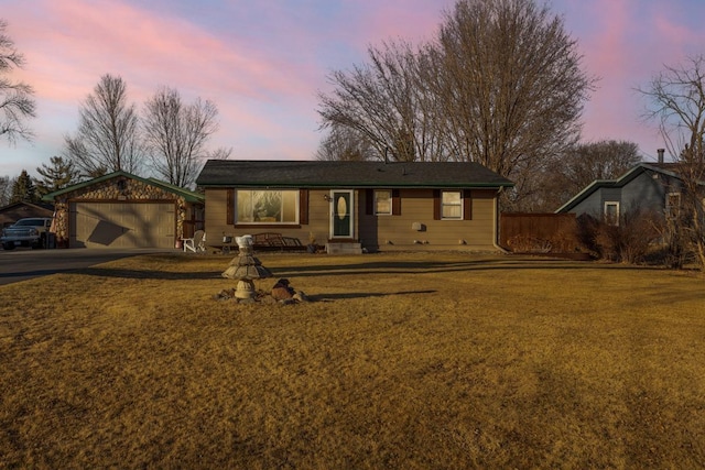 ranch-style house featuring a garage and a lawn