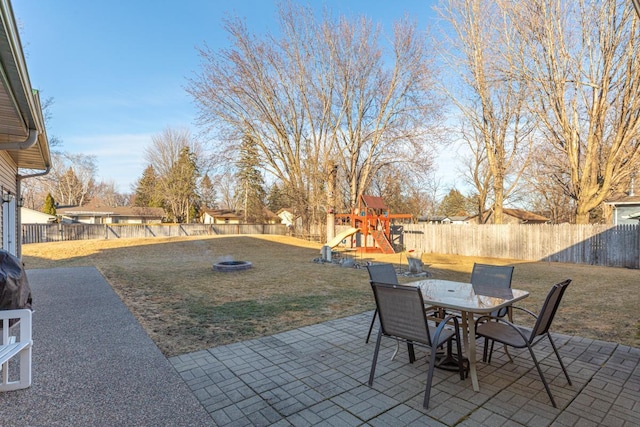 view of patio featuring a fenced backyard, outdoor dining area, and a playground