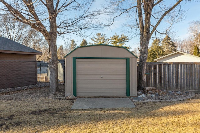 detached garage featuring a shed and fence