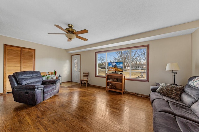 living area with a textured ceiling, wood finished floors, and a ceiling fan