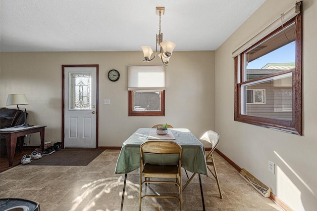 dining space featuring a chandelier, a wealth of natural light, visible vents, and baseboards