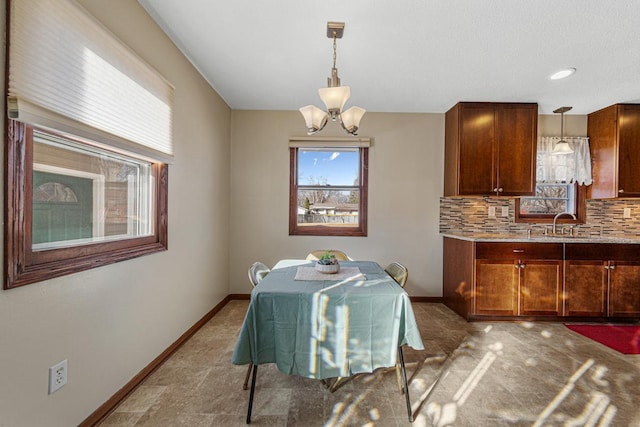 dining area featuring baseboards and a notable chandelier