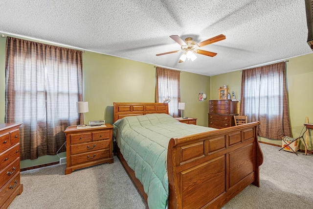 bedroom with a ceiling fan, light carpet, and a textured ceiling