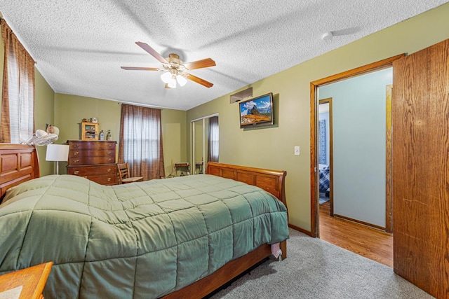 bedroom with a ceiling fan, carpet flooring, a textured ceiling, and baseboards