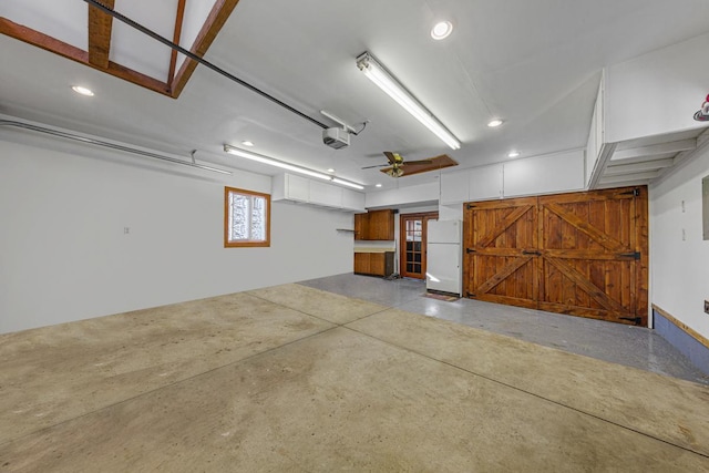 garage with recessed lighting, a garage door opener, and freestanding refrigerator