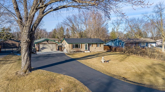 ranch-style house with driveway, a garage, a front lawn, and an outbuilding