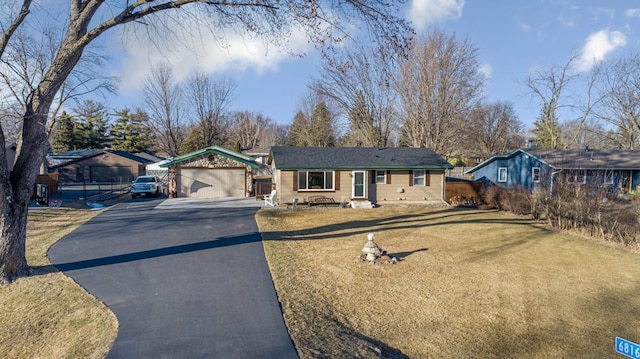 ranch-style house with an attached garage, fence, a front lawn, and aphalt driveway