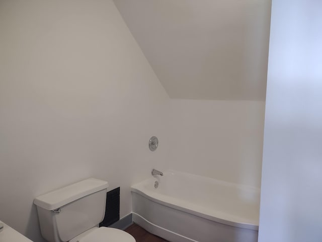 bathroom featuring hardwood / wood-style floors, a bathtub, toilet, and vaulted ceiling