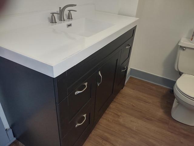 bathroom featuring toilet, hardwood / wood-style flooring, and vanity