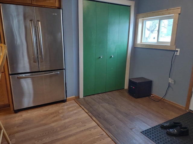 kitchen with stainless steel fridge and light hardwood / wood-style flooring