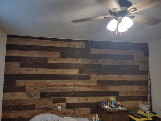 interior details with ceiling fan and wooden walls