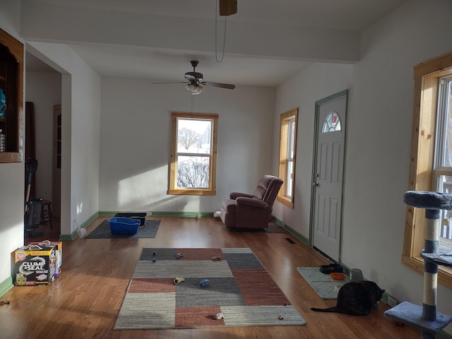 entryway featuring hardwood / wood-style flooring, beamed ceiling, and ceiling fan