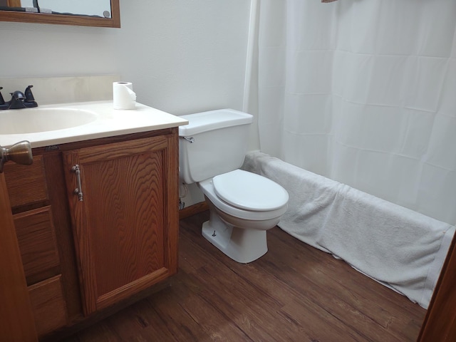 bathroom featuring toilet, wood-type flooring, and vanity