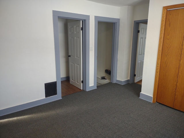 unfurnished bedroom featuring dark carpet