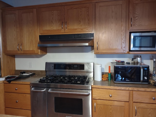 kitchen featuring under cabinet range hood, brown cabinets, and appliances with stainless steel finishes