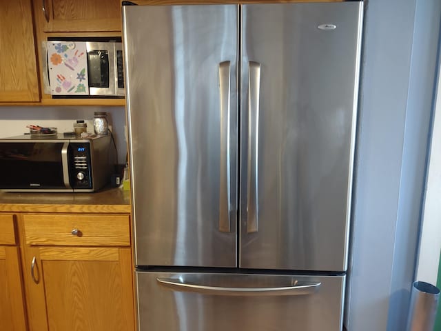 kitchen featuring brown cabinetry and freestanding refrigerator