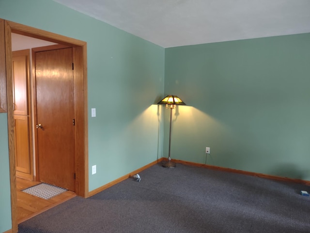 empty room featuring baseboards and carpet floors