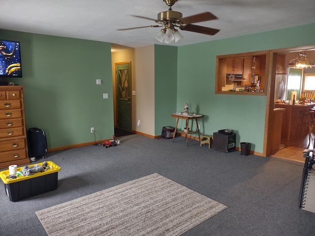 interior space with baseboards, carpet floors, and ceiling fan