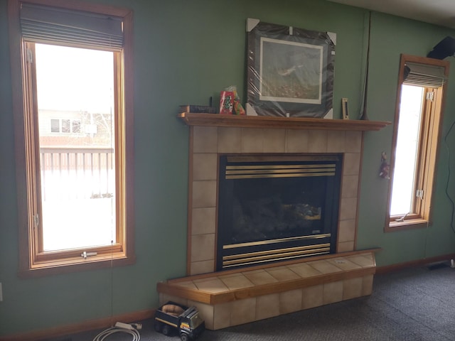 room details with baseboards, carpet flooring, and a tiled fireplace