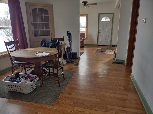 dining space featuring a ceiling fan, baseboards, and wood finished floors